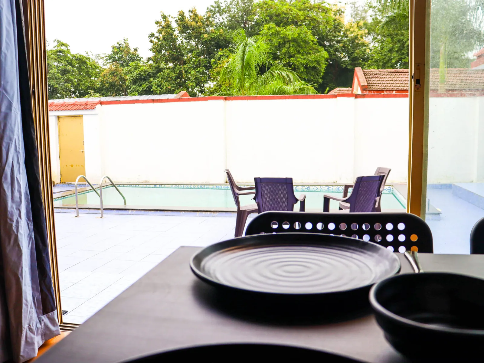Dining table by the window, looking out to the pool at Sihra Villa